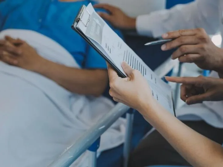 Medical staff reviewing provider verification charts and patient documentation for pain management medical credentialing services.